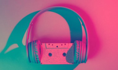 Ses kaseti olan kulaklıklar. 80 'ler. Retro dalga, pembe mavi neon ışık, morötesi. Üst görünüm, minimalizm