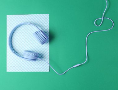 Mavi kulaklık ve mavi kablo yeşil yaratıcı arka plan. Minimalizm. Üst görünüm