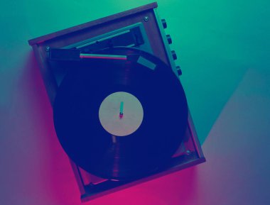 İp kaydı olan bir vinil çalar. Retro dalga, kırmızı mavi ışık, ultraviyole. Üst görünüm, minimalizm