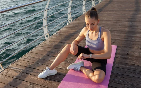 Fiatal Egészséges Vonzó Fitnesznő Szőnyegen Megnézi Óráját Strandon Reggeli Edzés — Stock Fotó