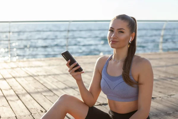 Slm Fit Vrouw Sportkleding Maakt Gebruik Van Een Smartphone Luistert — Stockfoto