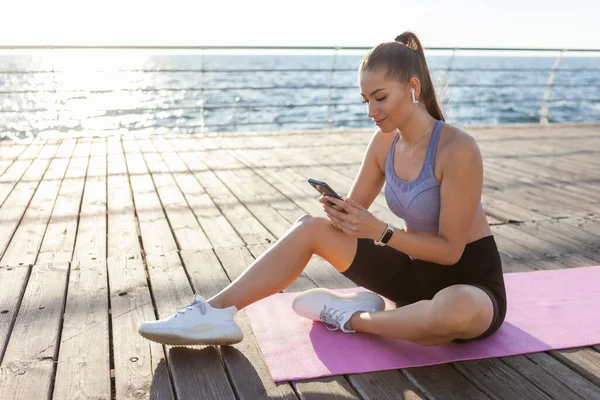 Slm Fit Vrouw Sportkleding Maakt Gebruik Van Een Smartphone Tijdens — Stockfoto