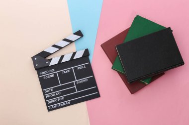 Film alkış tahtası ve renkli pastel arka plan kitapları. Kitaptan kitaba. Sinema endüstrisi, eğlence. Üst görünüm