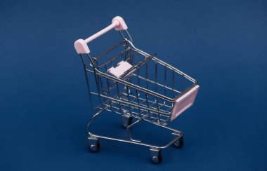 Klasik mavi arka planda mini alışveriş arabası