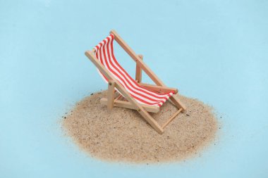 Yaz plajı seyahati konsepti. Kumlu bir adada küçük bir sahil sandalyesi.