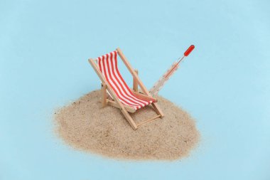 Yaz plajı seyahati konsepti. Kumlu bir adada mini plaj sandalyesi ve termometre.