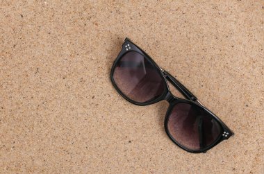 Yaz plajı seyahati konsepti. Kumda güneş gözlüğü