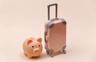 Seyahat ya da seyahat konsepti. Bej arka planda kumbarası olan mini plastik bir valiz..