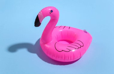 Mavi, güneşli arka planda şişirilebilir pembe flamingo. Yaz tatili kavramı. Minimalizm