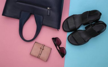 Pembe pastel arka planda yassı kadın aksesuarları. Sandaletler, çanta, deri cüzdan ve güneş gözlüğü. Üst görünüm