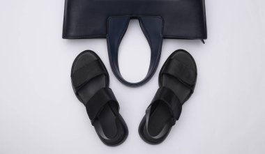 Kadın deri sandaletleri ve beyaz arka planda çanta. Kadın aksesuarları. Üst Manzara. Düz yatıyordu