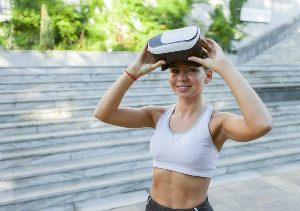 Fitness woman with virtual reality helmet outdoors