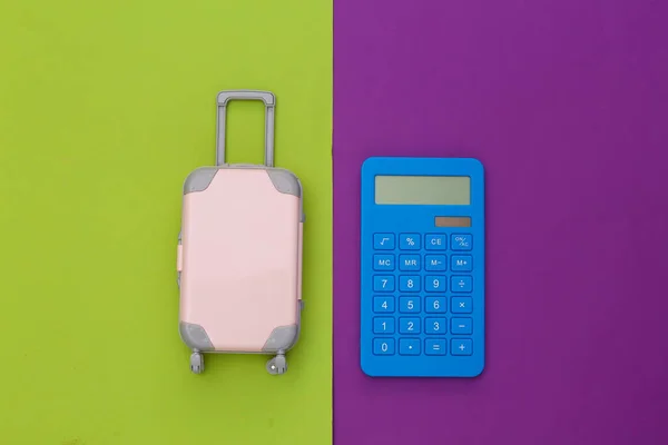 Cestovní Výdaje Mini Plastový Cestovní Kufr Kalkulačkou Zeleném Purpurovém Pozadí — Stock fotografie