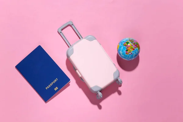 Мінімалізм Подорожей Міні Пластикова Туристична Валіза Паспорт Глобус Рожевому Фоні — стокове фото