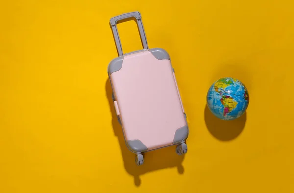 Minimalisme Voyage Mini Valise Voyage Plastique Globe Sur Fond Jaune — Photo