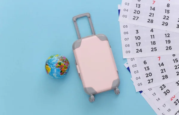 Tijd Reizen Mini Plastic Reiskoffer Wereldbol Maandelijkse Kalender Blauwe Achtergrond — Stockfoto