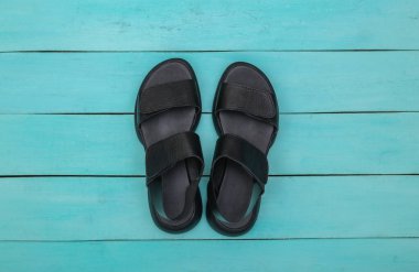 Mavi ahşap arka planda dişi deri sandaletler. Üst görünüm