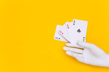 Sarı arka planda manken elinde dört as.
