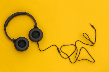 Sarı arka planda kablo siyah stereo kulaklık. Üst görünüm
