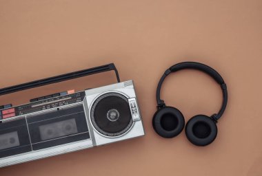 Boombox ses kayıt cihazı, kahverengi arka planda stereo kulaklıklar. Retro 80 'ler. Üst Manzara. Düz yatıyordu
