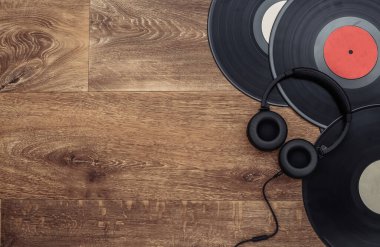 Retro vinil plaklar ve ahşap arka planda stereo kulaklıklar. Uzayı kopyala Üst Manzara. Düz yatıyordu