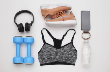 Spor malzemelerinin düz kompozisyonu, beyaz arka planda giysiler. Spor, spor ve sağlıklı yaşam tarzı konsepti. Üst görünüm