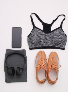 Spor malzemelerinin düz kompozisyonu, beyaz arka planda giysiler. Spor, spor ve sağlıklı yaşam tarzı konsepti. Üst görünüm