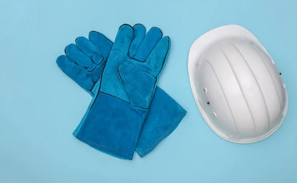 青い背景に作業用手袋と建設安全ヘルメット トップ表示 — ストック写真