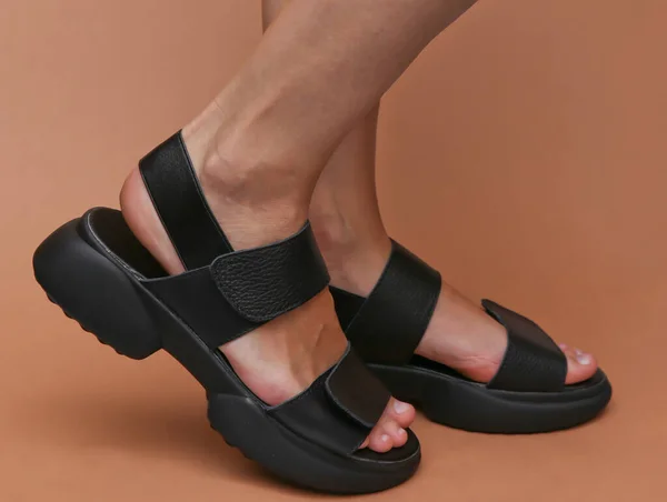 Frauenfüße Modischen Ledersandalen Auf Braunem Hintergrund — Stockfoto