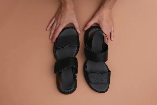 Las Manos Femeninas Sostienen Sandalias Cuero Negro Moda Sobre Fondo — Foto de Stock