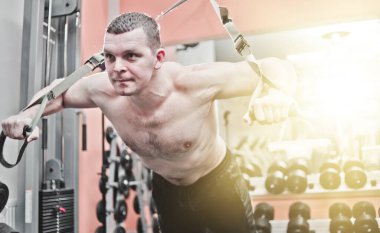 Güçlü bir adam spor salonunda şınav çekerek şınav çeker. 