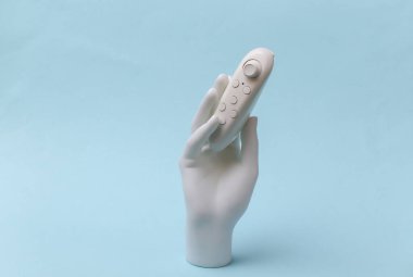 Mavi arka planda modern joystick tutan beyaz manken.