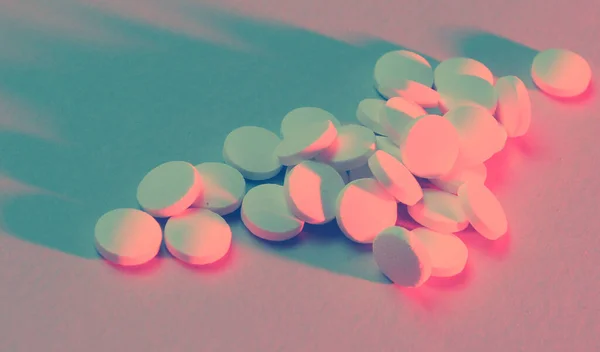 吸毒成瘾 依赖的概念 许多带有红蓝色霓虹灯的白色药丸 — 图库照片