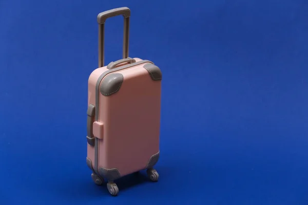 旅行や旅行のコンセプト クラシックなブルーの背景にミニプラスチック旅行スーツケース カラー2020 — ストック写真