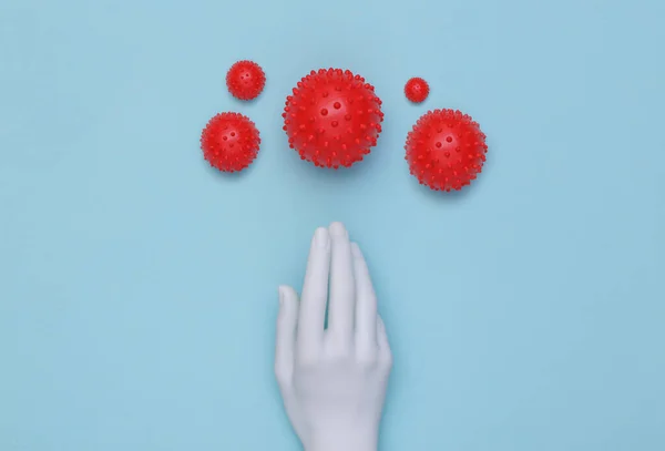 Mannequin hand and virus strain on a blue background. Covid-19. Top view