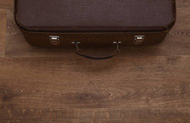 Seyahat konsepti. Ahşap zeminde eski bir seyahat çantası. Üst görünüm