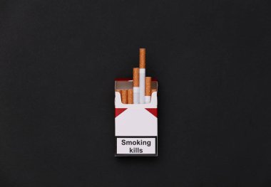 Pack of cigarettes on black background. Smoking kills. Top view clipart