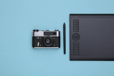 Mavi zemin üzerinde kalem ve kamera olan grafiksel tablet. Üst görünüm