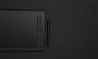 Siyah arkaplanda kalem bulunan grafiksel tablet. Üst görünüm