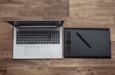 Ahşap kaplamalı dizüstü bilgisayar ve grafiksel tablet. Üst görünüm.