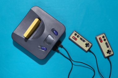 Mavi arka planda joystickli Retro video oyun konsolu. Üst görünüm