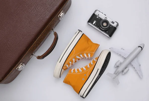 旅行概念 复古风格的运动鞋 旧旅行箱 白色背景的相机 顶部视图 — 图库照片