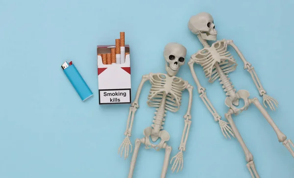 Förpackning Med Cigaretter Och Skelett Blå Bakgrund Dålig Vana Rökning — Stockfoto