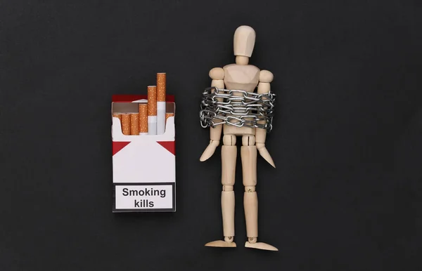 吸烟成瘾 木制木偶 铁链包裹 黑底香烟包 — 图库照片