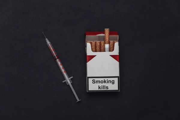 Rökning Och Narkotikamissbruk Förpackning Med Cigaretter Och Spruta Svart Bakgrund — Stockfoto