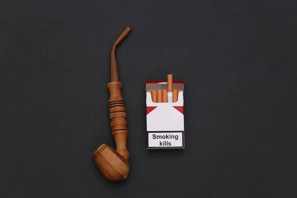 黒い背景に煙管とタバコのパック — ストック写真