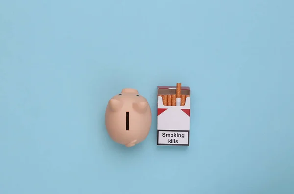 Porquinho Maço Cigarros Num Fundo Azul Custos Fumar Vista Superior — Fotografia de Stock