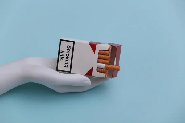 Skyltdocka Hand Hålla Förpackning Cigaretter Blå Bakgrund — Stockfoto