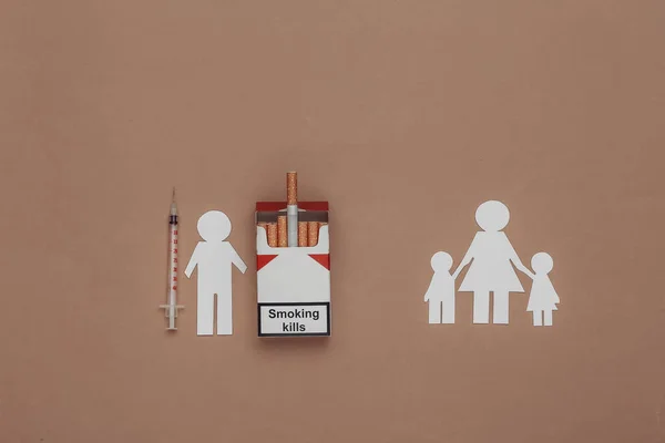 Paper cut family separated cigarettes and drug syringe. Destructive family concept. Smoking and drug addiction