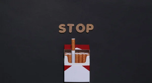 タバコは止めて 黒の背景にタバコのパック — ストック写真